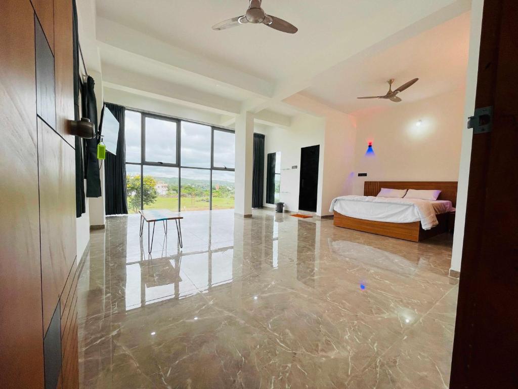 a bedroom with a bed and a table at Hotel O DSP Lodge And Restaurant in Jadhavwadi