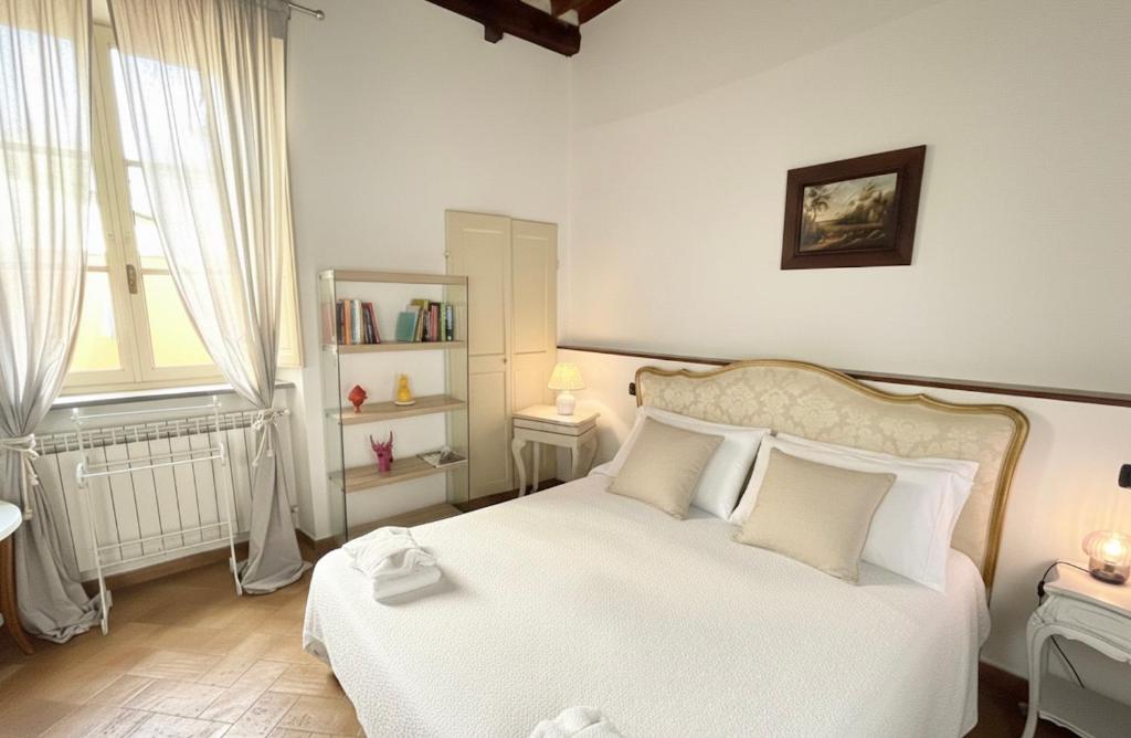 Un dormitorio con una cama blanca con sábanas y almohadas blancas. en Dimore della Seta - Il Filo di Seta, en Lucca