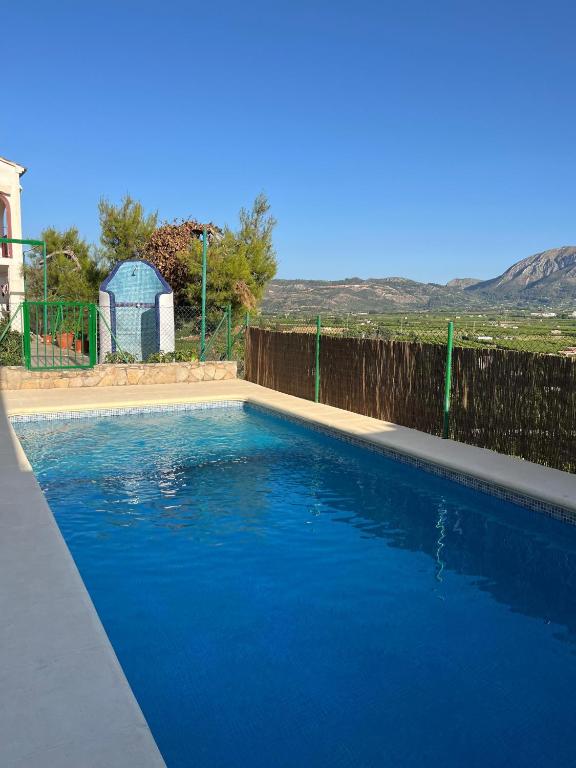 a swimming pool with blue water in a yard at La Casa Maria in Pego