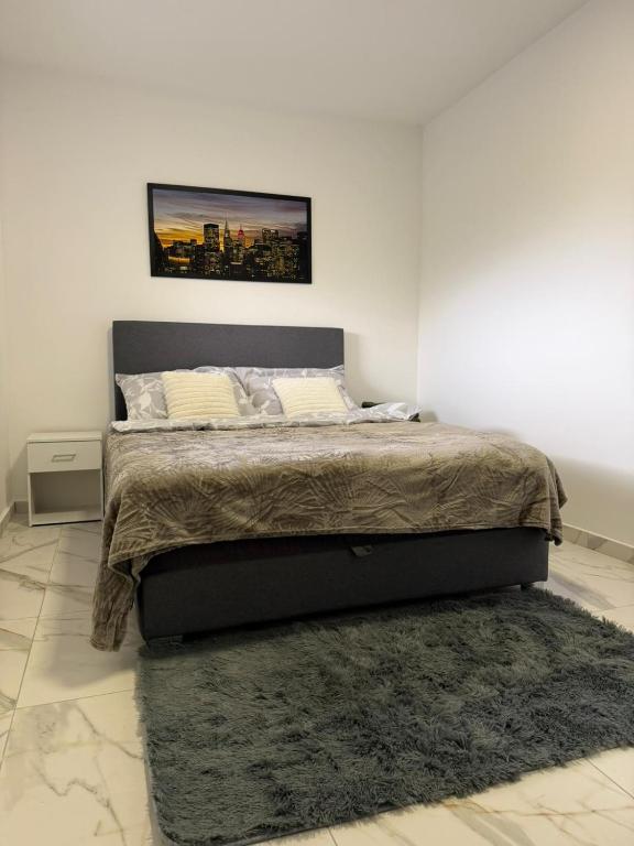 a bedroom with a large bed with a rug at Apartman na dan Pecinci in Pećinci