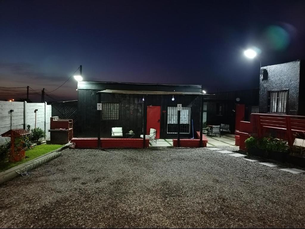 a house with a red door at night at Cabañas Mediterraneas in Pichidangui