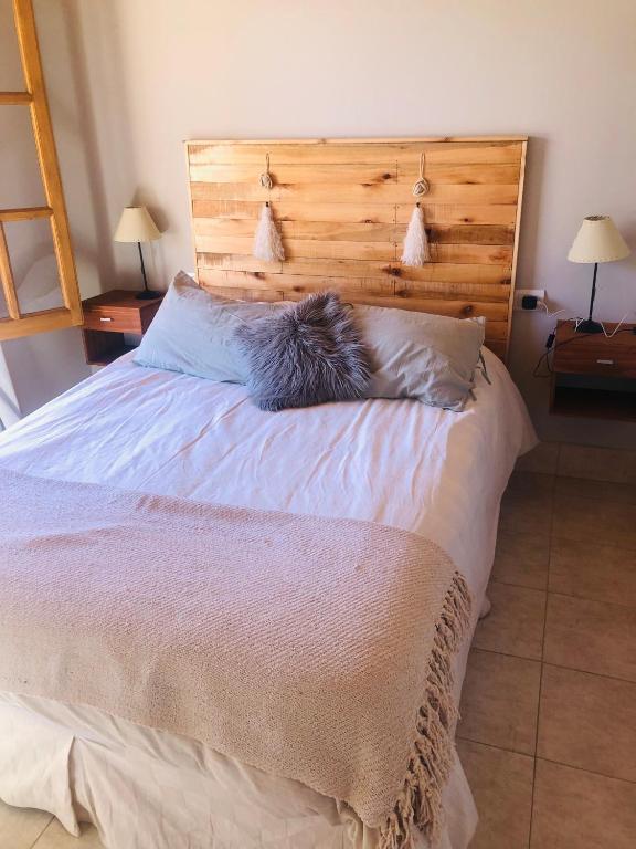 a cat sleeping on a bed in a bedroom at Cabañas El bosque DLM in Uspallata