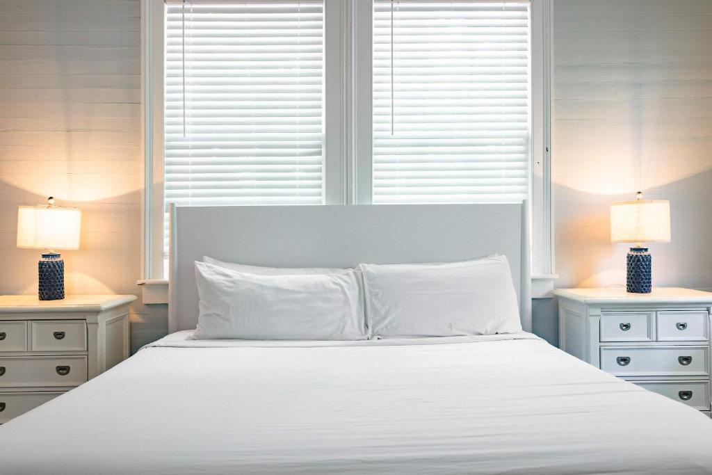 a bedroom with a large white bed with two lamps at Sweet Caroline in Key West