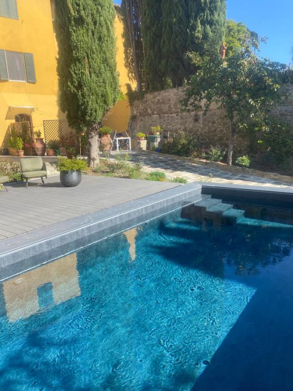 フィレンツェにあるIl Portico di Margheritaの建物の隣にある青い大型スイミングプール