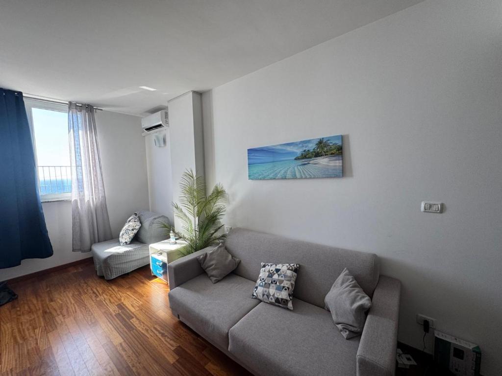 a living room with a couch and a window at B&C Riviera Appartment in Sanremo