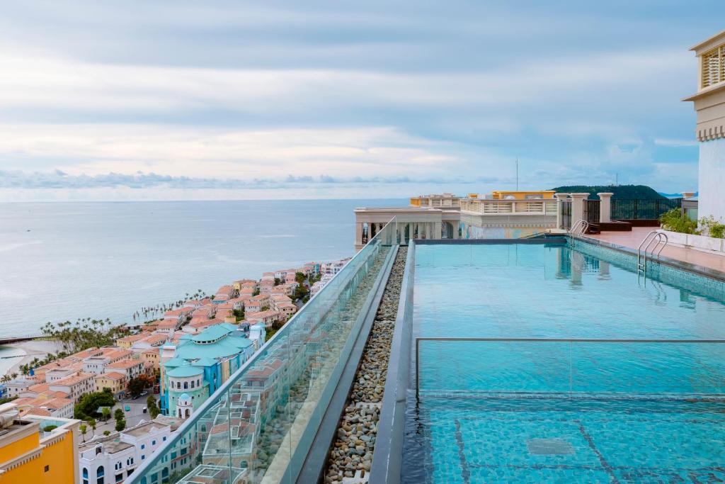 a swimming pool on top of a building with the water at Atermis Regency Hillside Phu Quoc - Sea & Fireworks view- Gym & Pool Access in Phu Quoc