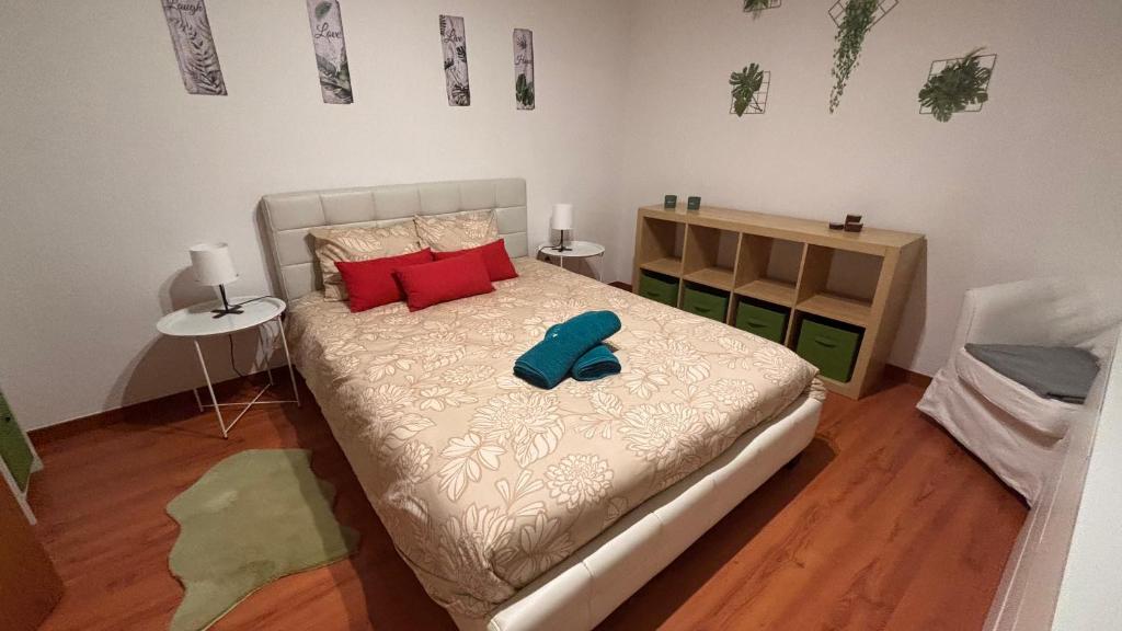 ein Schlafzimmer mit einem Bett mit blauen Hausschuhen darauf in der Unterkunft Casinha no coração do Oeste in Cadaval