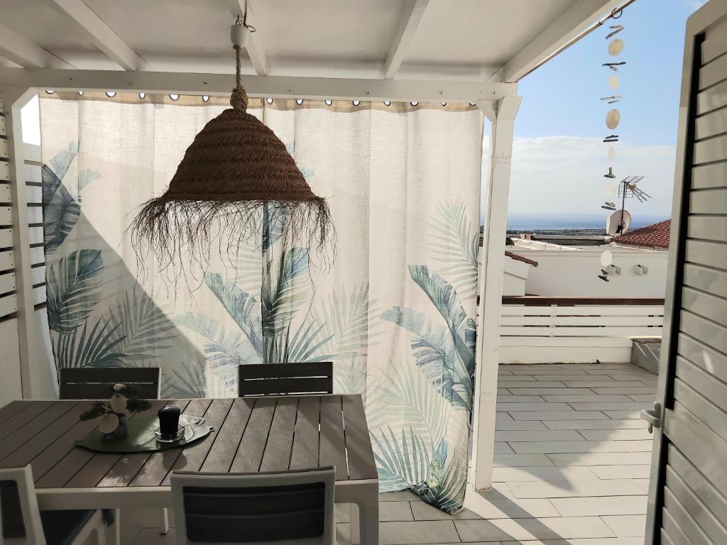 a patio with a table and a view of the ocean at Sunny Bungalow in Caleta De Fuste