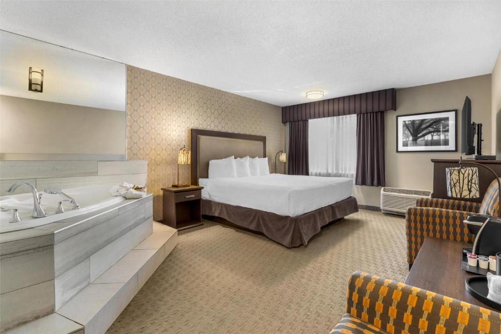 a hotel room with a bed and a bath tub at Best Western Plus Country Meadows Inn in Aldergrove