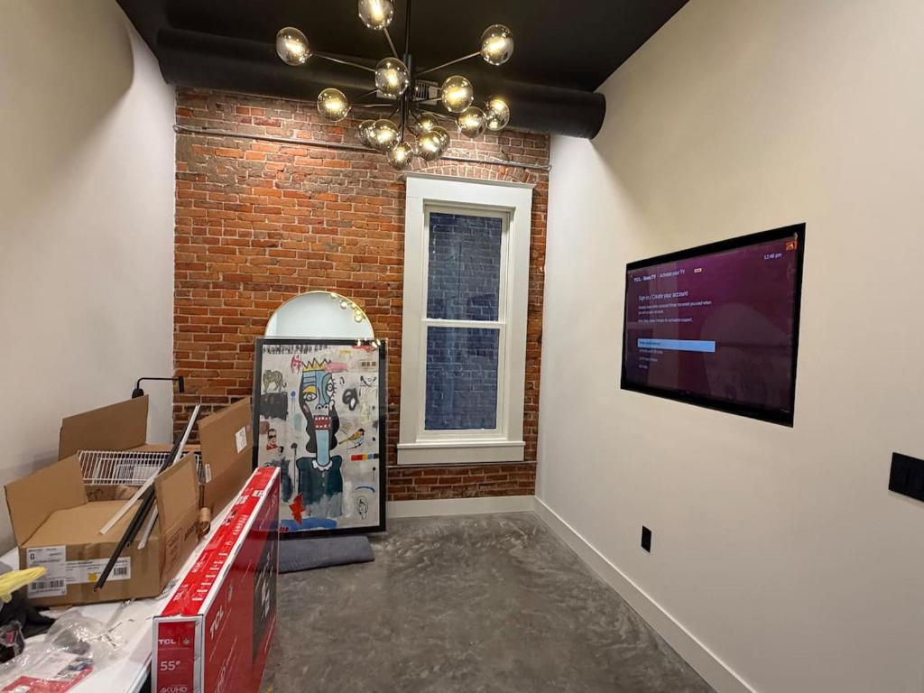 a room with a television and a wall with boxes at The Dim Light - One Bedroom in Paducah