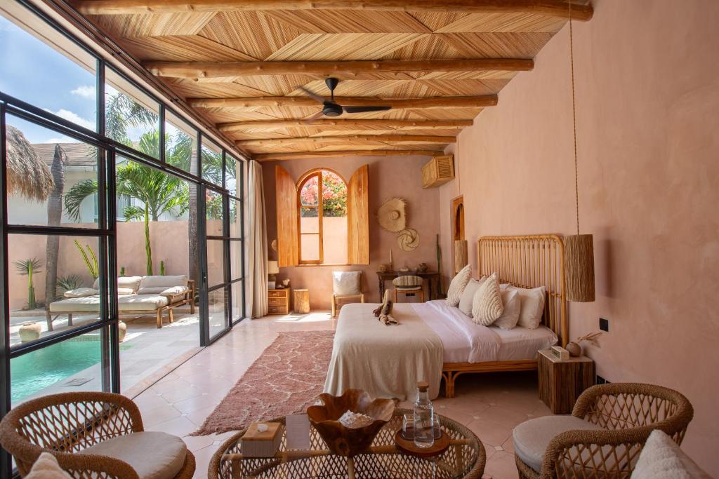 a bedroom with a bed and a living room at Villa Pinkaboo - Gorgeous and Luxury One-Bedroom Villa in the Heart of Canggu in Canggu