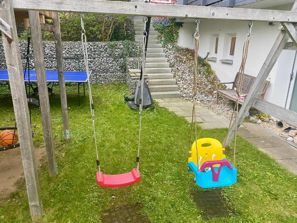 two swings in a yard with a table and a bench at 2 Zimmer Ferienwohnung mit Terrasse fußläufig zu S-Bahn nach München und See in Wörthsee