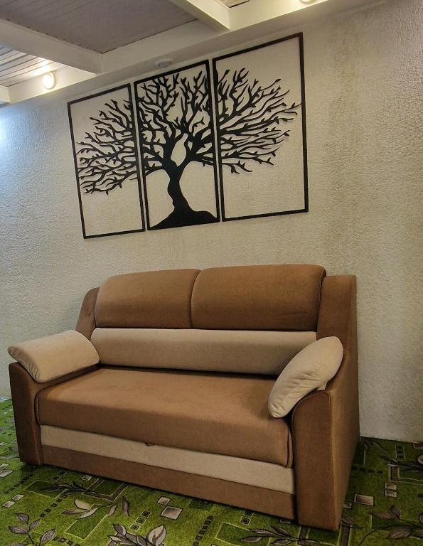 a couch in a room with three pictures on the wall at Dostoievski 4 in Bălţi