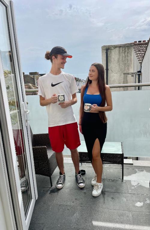 Hotel Kemp Town Sea View Balcony Apartment, a man and a woman standing on a balcony at Kemp Town Sea View Balcony Apartment in Brighton & Hove