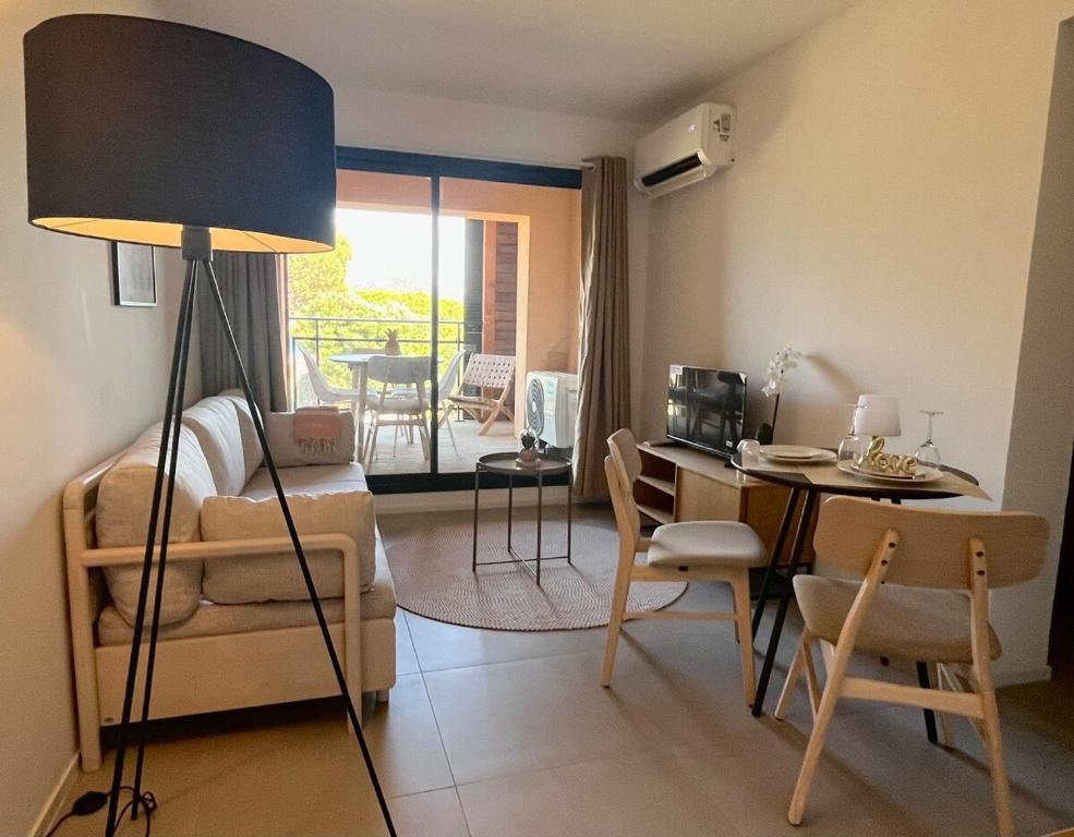 un salon avec un canapé, une table et des chaises dans l'établissement amazing sea front apartment, à Pianottoli-Caldarello