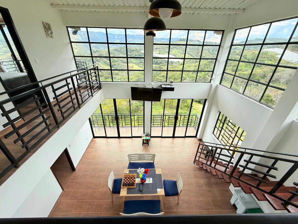 una grande stanza con un tavolo, sedie e finestre di Casa Mirador de la Montaña - Campestre - Villa de Leiva - Moniquira a Santa Sofía