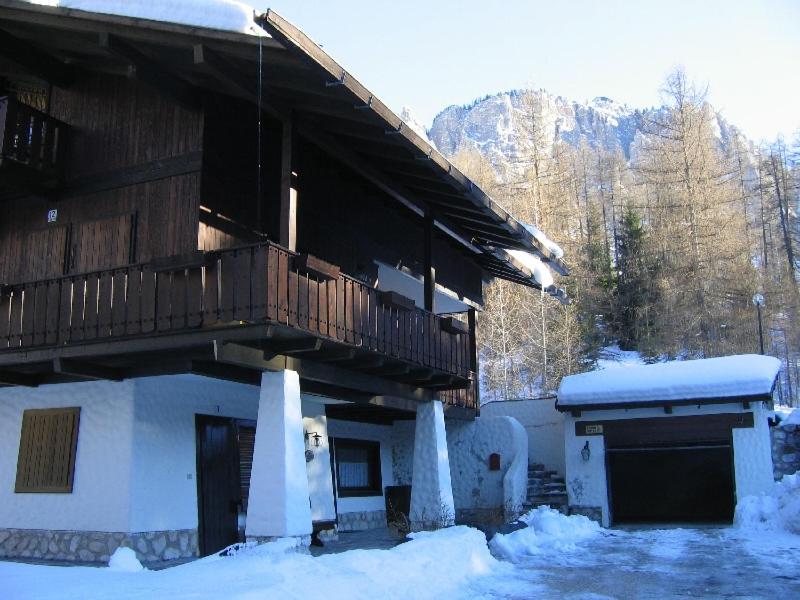 a building with a deck and snow on the ground at Appartamento in chalet ampezzano in Alvera