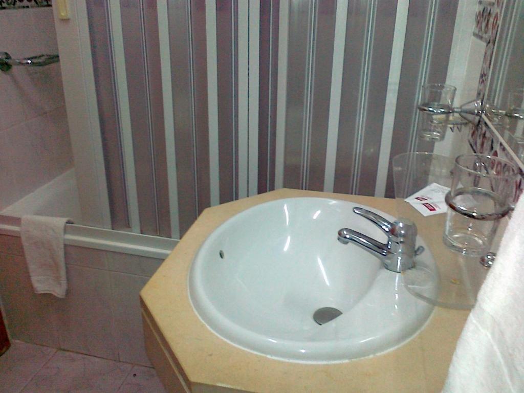 a bathroom with a sink and a bath tub at Real Caparica Hotel in Costa da Caparica