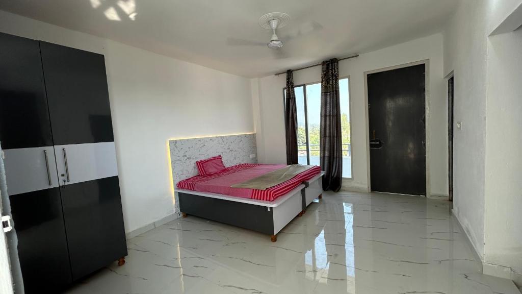 a bedroom with a bed in a room with a window at Air Rooms in Lohārakot