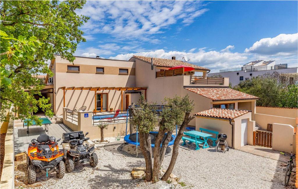 a house with two atvs parked in front of it at Beautiful villa Lona with private pool near Pula in Peroj