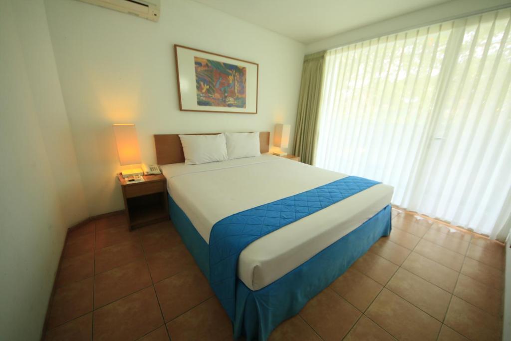 Postel nebo postele na pokoji v ubytování Concordia Hotel Bumi Sangkuriang Bandung