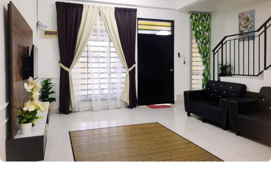 a living room with a black couch and a black door at 12pax Senai RestHome near Senai Airport in Kampung Seelung