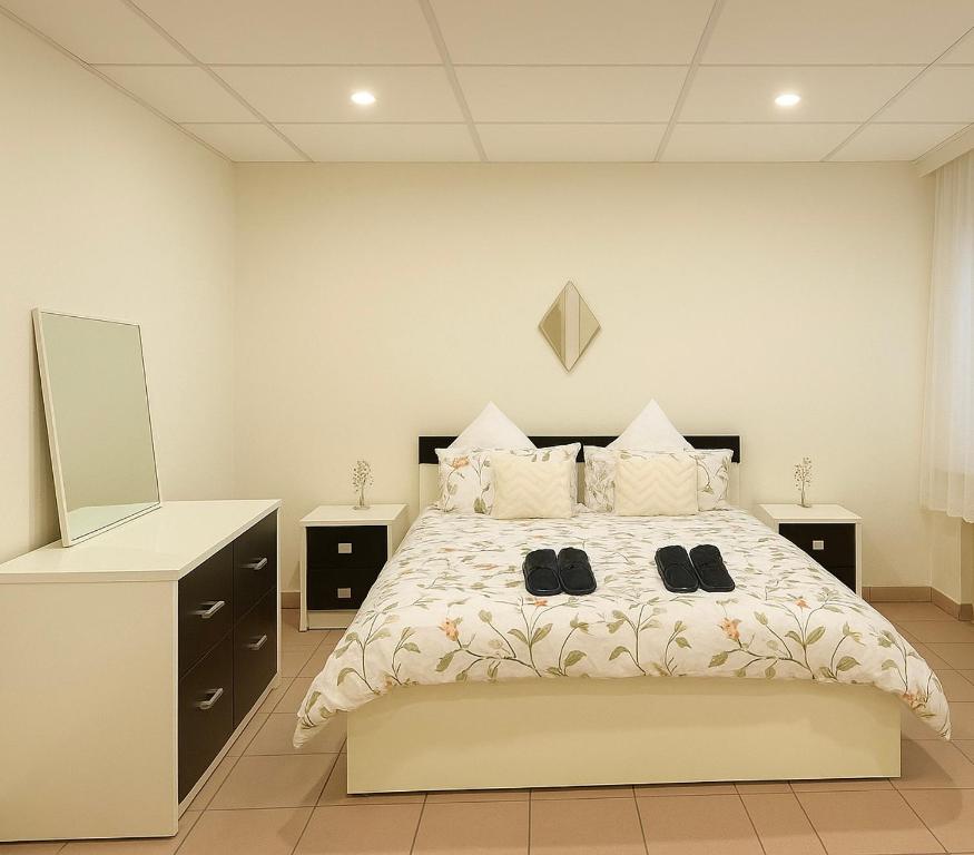 Un dormitorio con una cama grande con zapatos encima. en Gelijkvloers appartement in hartje Menen, en Menen