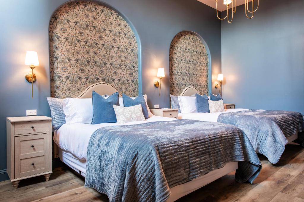 two beds in a room with blue walls at Hollyhock Suite 506 in Louisville