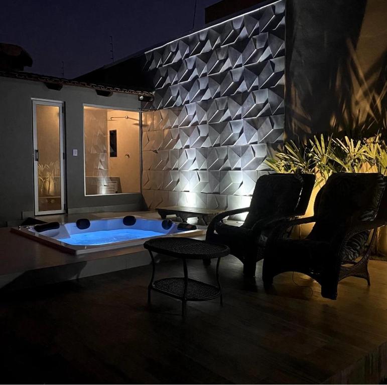 een woonkamer met een hottub en twee stoelen bij CasaBela in Juatuba