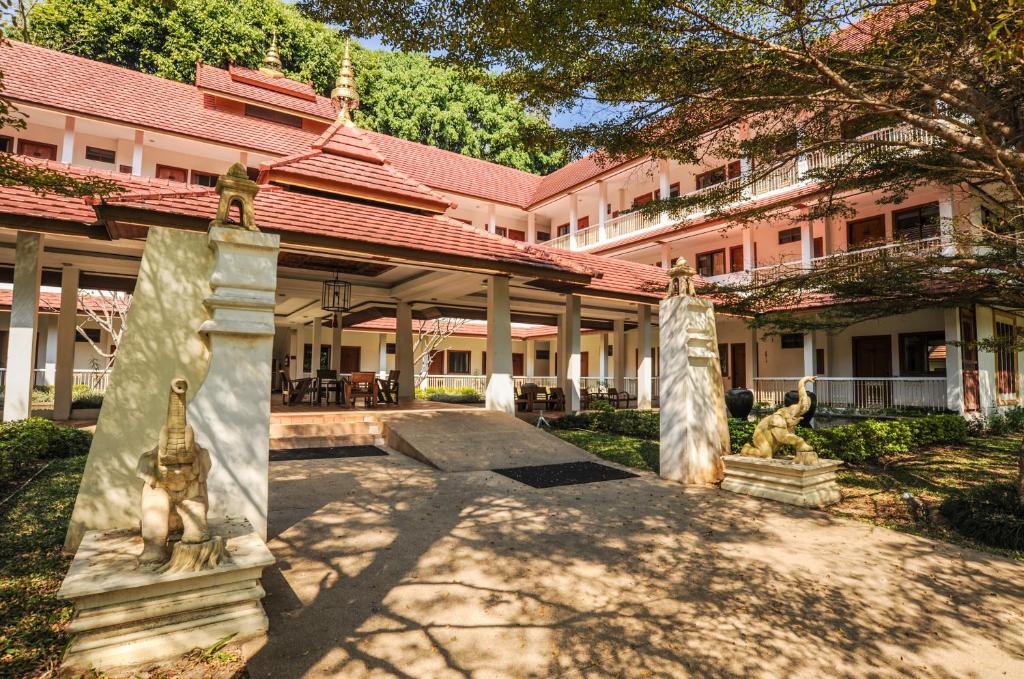 a large pink building with statues in front of it at Suan Bua Hotel & Resort in Ban Pong