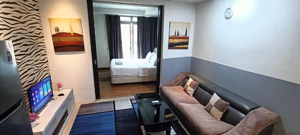 Una sala de estar con un sofá y un espejo. en Grand Apartment, en Dhaka