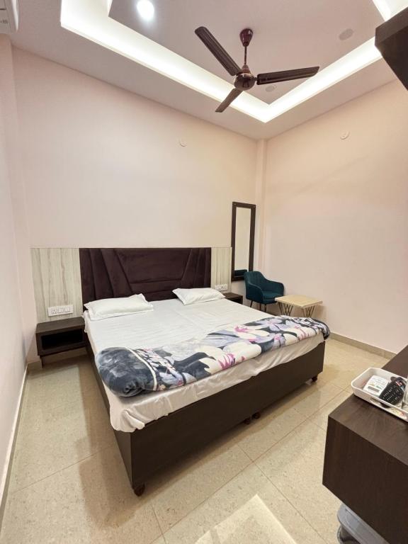 Mehtab guest house في جالاندهار: غرفة نوم بها سرير ومروحة سقف