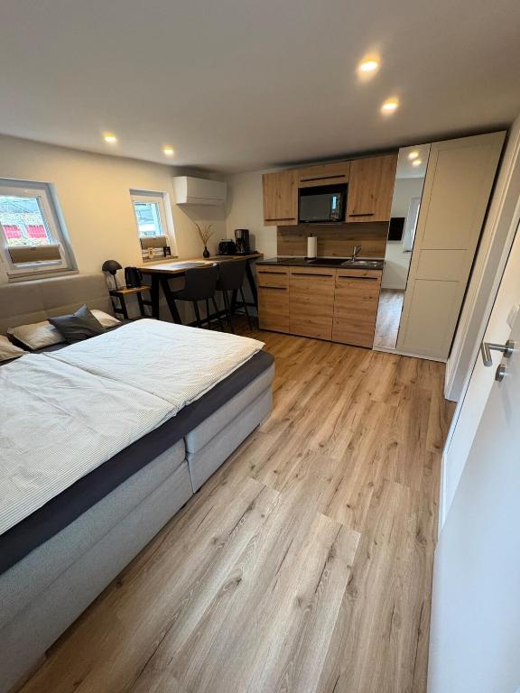 a bedroom with a large bed and a kitchen at LippeStay - Modernes Apartment für 2 in Werne an der Lippe