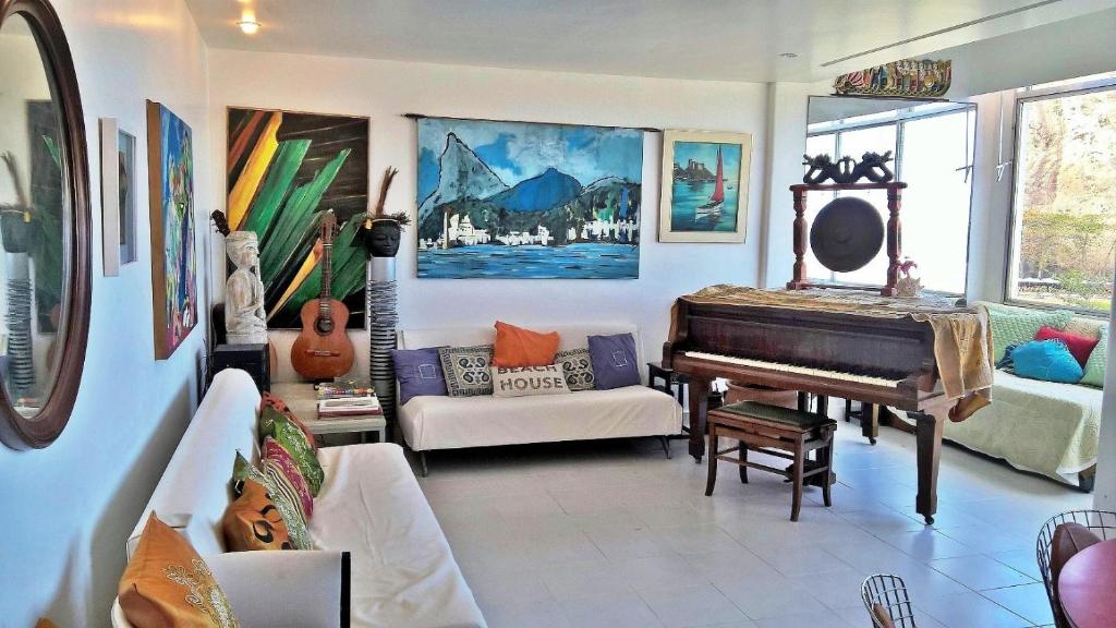 sala de estar con piano y sofá en Ocean apartment, en Río de Janeiro