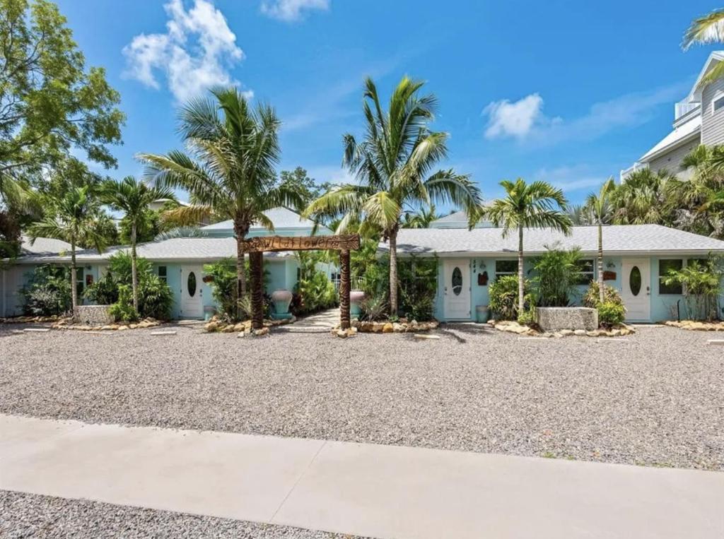 a house with palm trees in front of it at Book Me Baby! Wildflower Inn Siesta Key #5 Pineapple in Siesta Key