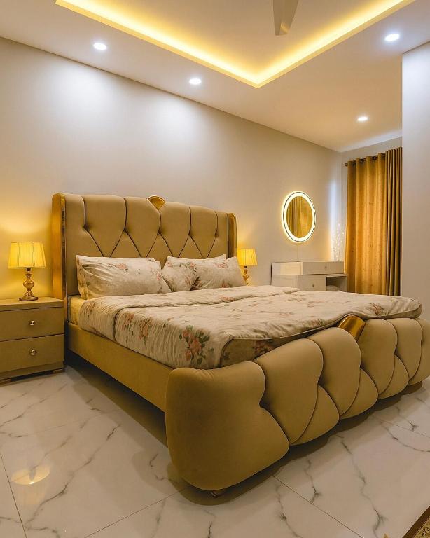 1 cama grande con cabecero acolchado grande en un dormitorio en Luxury 1 Bed Apartment - Civic Centre, en Rawalpindi