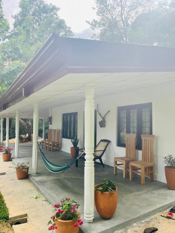a white gazebo with a hammock on a patio at Holiday Home Rathnaella in Hassalaka