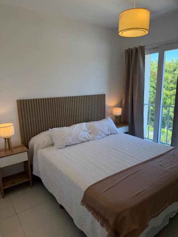 a bedroom with a bed and a large window at Segundo hogar in Luján