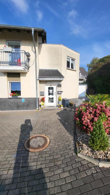 a building with a driveway with a door and flowers at bei Elena in Burscheid