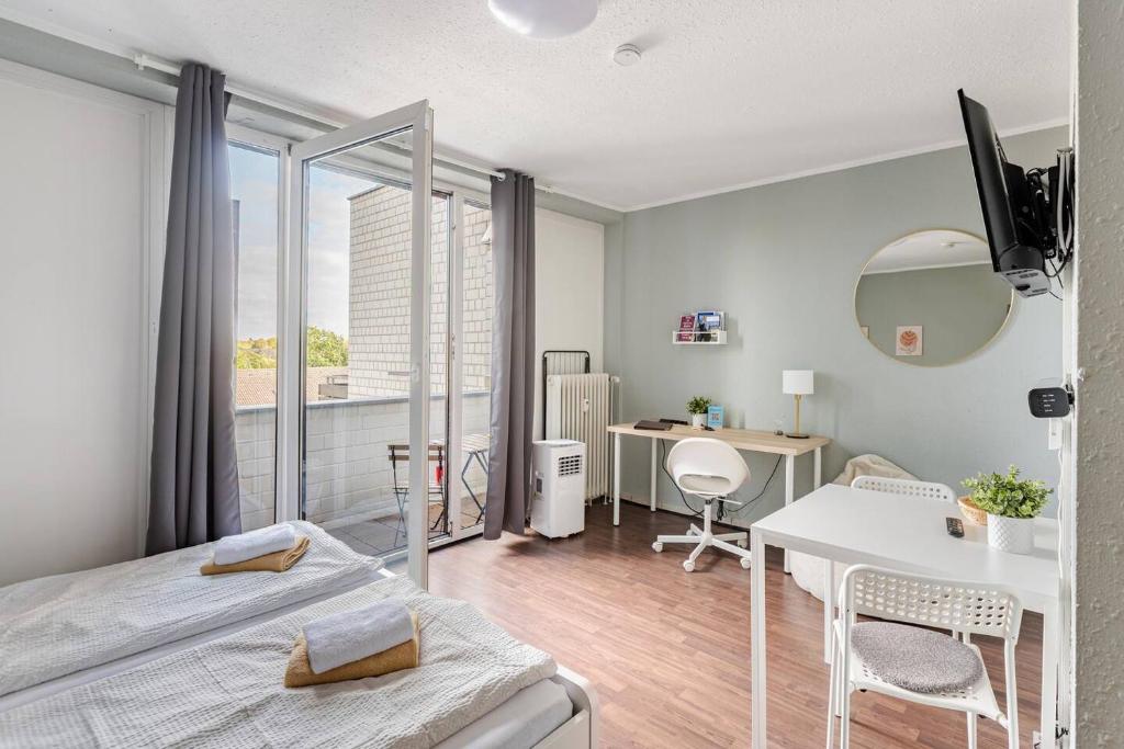 a bedroom with a bed and a desk and a table at Exklusiv Küche Office Streaming Minibar in Bonn