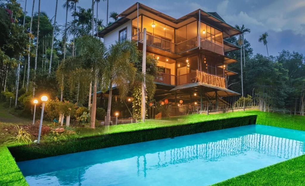 a house with a pool in front of it at GreensVista Pool Wayanad AC Pillar Homestay near Natural Stream and Amazing View in Panamaram