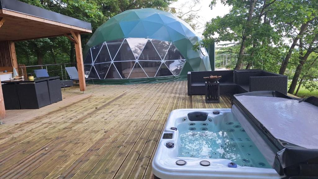 a hot tub on a deck with a gazebo at Dôme du haut bearn in Monein