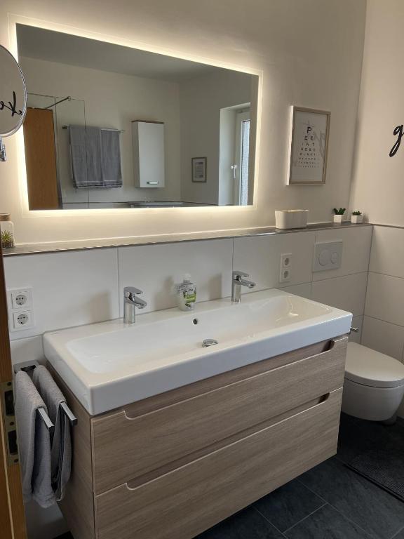 a bathroom with a white sink and a mirror at Ferienwohnung Dammer in Niederkrüchten