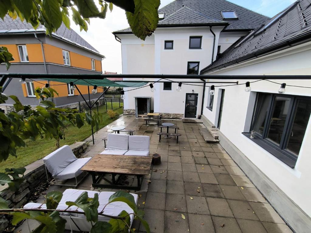 a patio with white chairs and a wooden table at Apartmány Pekárna in Staré Město