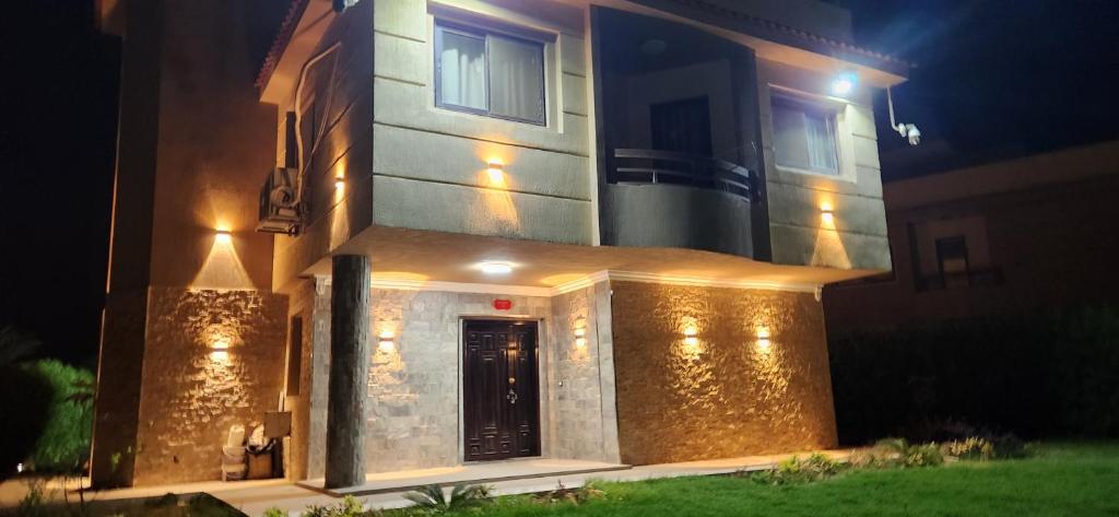 a house with lights on the side of it at night at فيلا مستقلة 5 غرف مطلة على البحر - منتجع بلو باي اسيا السخنة Villa Blue bay Asia Sokhna in Ain Sokhna