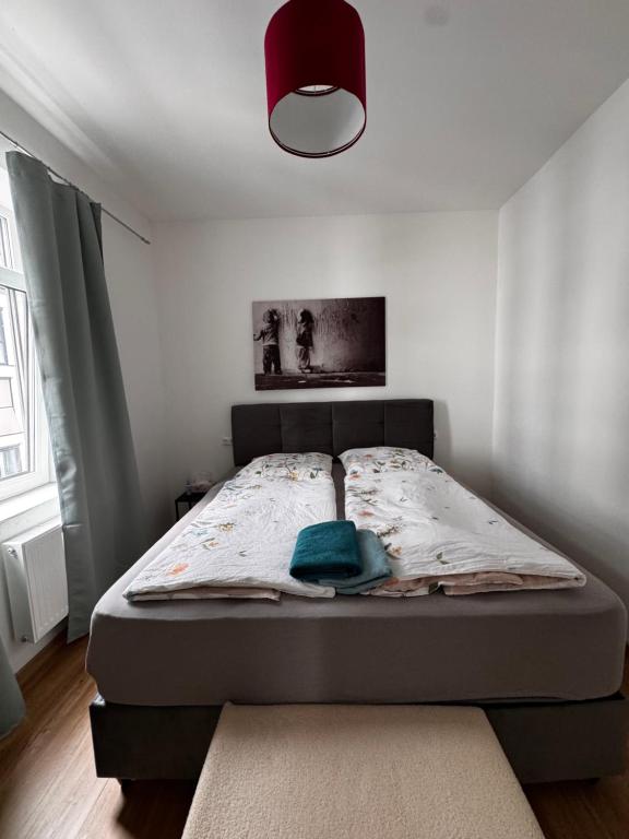 a bed in a small bedroom with a red light at Aby Wohnungen in Rosenheim