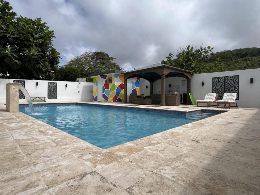 una piscina con gazebo accanto a una casa di Sea Breeze Tunnel Hideaway 2 a Quebradillas