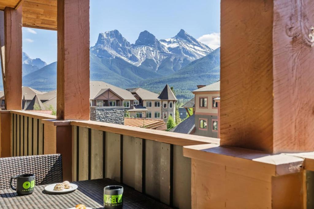 einen Balkon mit einem Tisch und Bergblick in der Unterkunft Spacious Rockies Escape near Banff Hot tub and Gym in Canmore