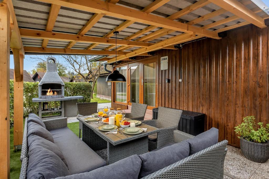 a patio with a table and chairs and a fireplace at Superior Holiday Home Fortuna in Čatež ob Savi