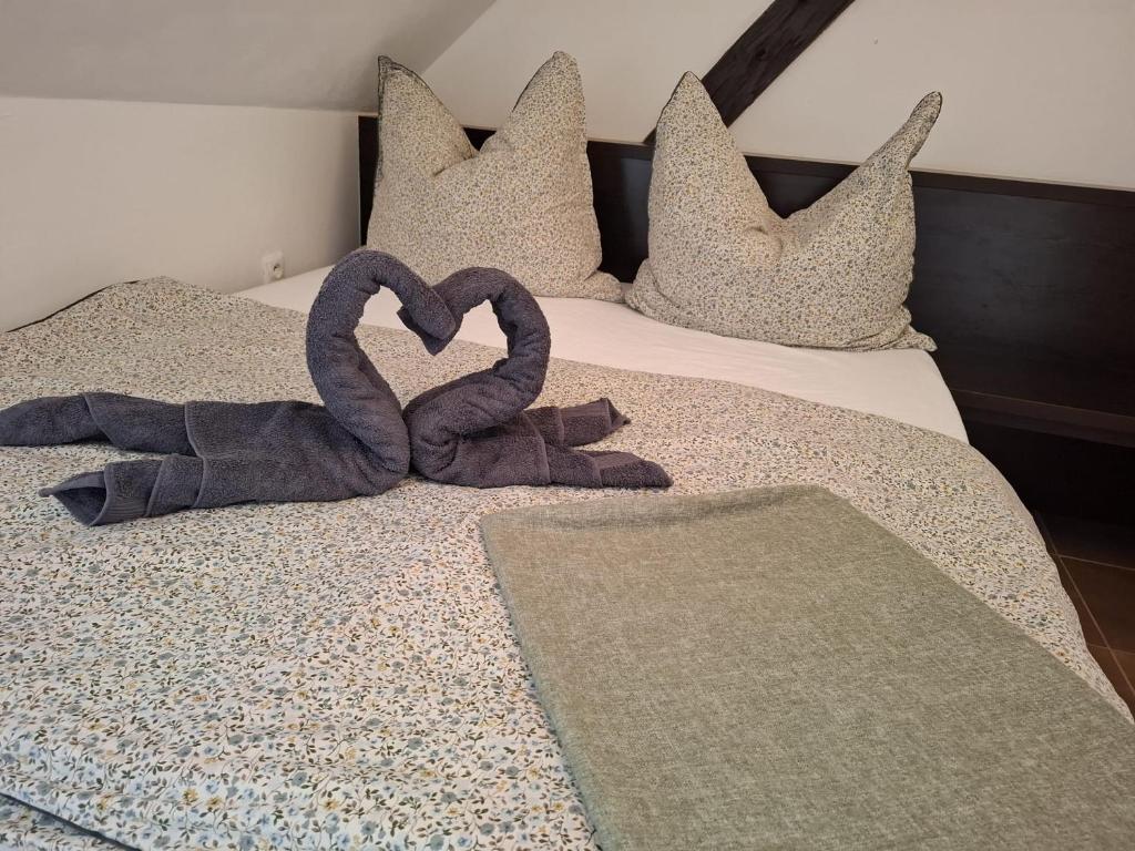 two towels in the shape of a heart on a bed at Apartmán Coralina in Zvolen